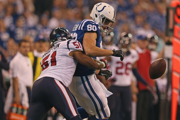 INDIANAPOLIS, IN - DECEMBER 30:  Coby Fleener #80 of the Indianapolis Colts attempts a catch under pressure from Darryl Sharpton #51 of the Houston Texans at Lucas Oil Stadium on December 30, 2012 in Indianapolis, Indiana. The Colts defeated the Texans 28-16.  (Photo by Jonathan Daniel/Getty Images)