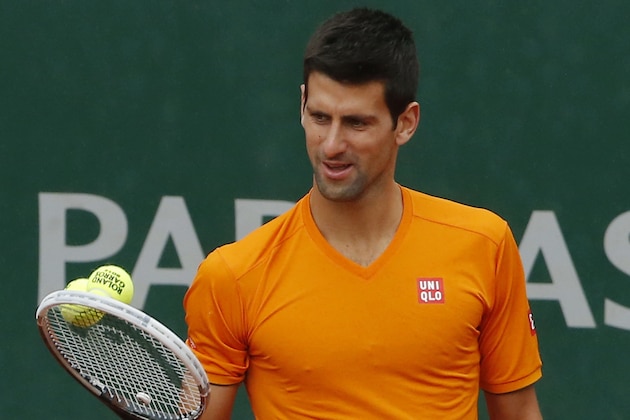 Novak Djokovic, of Serbia, looks at the balls on his racket during a training session for the French Open tennis tournament, at the Roland Garros stadium in Paris, Saturday, May 24, 2014. The French Open tennis tournament starts Sunday. (AP Photo/Michel Euler)