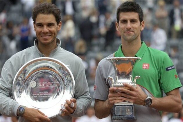 Serbia's Novak Djokovic, right, holds the winner's trophy, as Spain's Rafael Nadal holds the second placed trophy during the awarding ceremony of the Italian Open tennis tournament, in Rome, Sunday, May 18, 2014. Novak Djokovic extended his recent dominance over Rafael Nadal by rallying for a 4-6, 6-3, 6-3 victory Sunday to win the Italian Open for the third time. (AP Photo/Andrew Medichini)