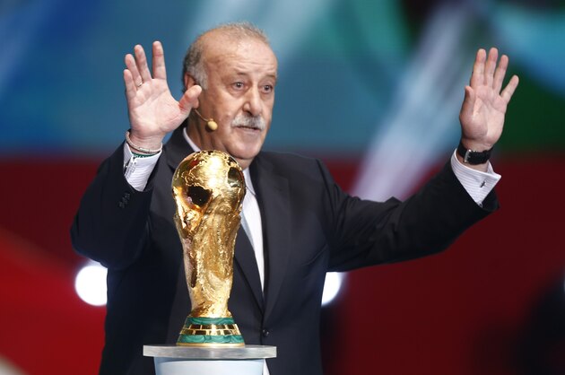 Spain head coach Vicente Del Bosque brings the World Cup trophy onto the stage during the draw ceremony for the 2014 soccer World Cup in Costa do Sauipe near Salvador, Brazil, Friday, Dec. 6, 2013. (AP Photo/Victor R. Caivano)