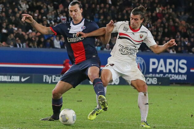 Paris Saint Germain's Zlatan Ibrahimovic, left, and Serbian Nemanja Pejcinovic, right, vie the ball during a French League One soccer match Paris Saint Germain against Nice at Parc des Princes stadium in Paris, Saturday, Nov. 9, 2013. Paris Saint Germain won 3-1. (AP Photo/Michel Euler)