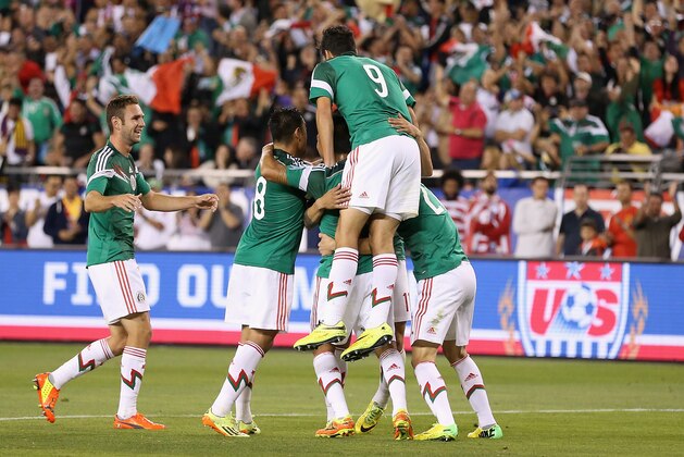 GLENDALE, AZ - APRIL 02:  Players from Mexico celebrate around Alan Pulido #11 (not pictured) after he scored a second half goal against USA during the International Friendly at University of Phoenix Stadium on April 2, 2014 in Glendale, Arizona. Mexico and USA played to a 2-2 tie. (Photo by Christian Petersen/Getty Images)