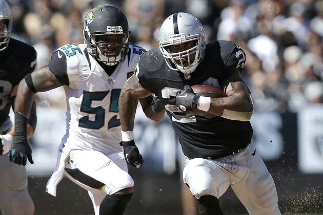 Oakland Raiders running back Darren McFadden runs in front of Jacksonville Jaguars outside linebacker Geno Hayes (55) during the third quarter of an NFL football game in Oakland, Calif., Sunday, Sept. 15, 2013. (AP Photo/Marcio Jose Sanchez)