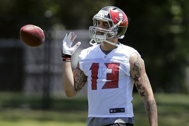 Tampa Bay Buccaneers first-round draft pick Mike Evans flips the football during NFL football rookie camp Friday, May 16, 2014, in Tampa, Fla. Evans, the seventh pick overall, played at Texas A&M. (AP Photo/Chris O'Meara)