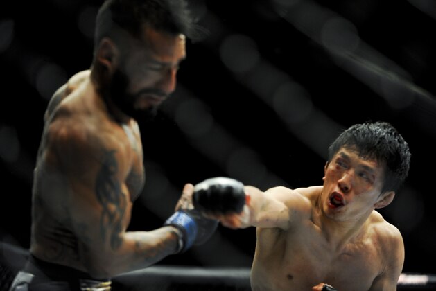 May 24, 2014; Las Vegas, NV, USA; Takeya Mizugaki (red) throws a punch at Francisco Rivera (blue) during their UFC 173 bantamweight bout at MGM Grand Garden Arena. Mizugaki won the bout by unanimous decision. Mandatory Credit: Stephen R. Sylvanie-USA TODAY Sports