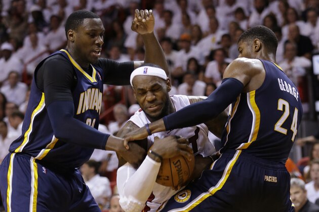 Indiana Pacers center Ian Mahinmi, left, and forward Paul George (24) attempt to block Miami Heat forward LeBron James during the second half of Game 4 in the NBA basketball Eastern Conference finals playoff series, Monday, May 26, 2014, in Miami. (AP Photo/Wilfredo Lee)