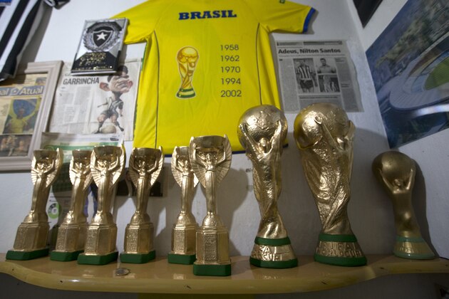 Replicas of FIFA World Cup trophies sit at the home of Jarbas Meneghini, in Rio de Janeiro, Brazil, Tuesday, May 20, 2014. Meneghini, a mechanica, makes replicas of the World Cup trophy since 1996, after he saw former soccer player Dunga holding up the trophy in 1994, when Brazil won the WCup in the U.S. Most of his sales are done by phone or through his Facebook page. Sometimes he delivers orders to clients by meeting them during games at Rio de Janeiro’s Maracana stadium. (AP Photo/Silvia Izquierdo)
