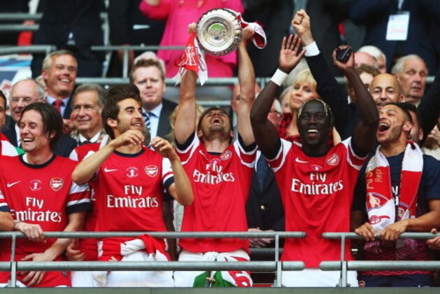 LONDON, ENGLAND - MAY 17:  Winning goalscorer Aaron Ramsey of Arsenal (C) lifts the trophy in celebration after the FA Cup with Budweiser Final match between Arsenal and Hull City at Wembley Stadium on May 17, 2014 in London, England.  (Photo by Clive Mason/Getty Images)