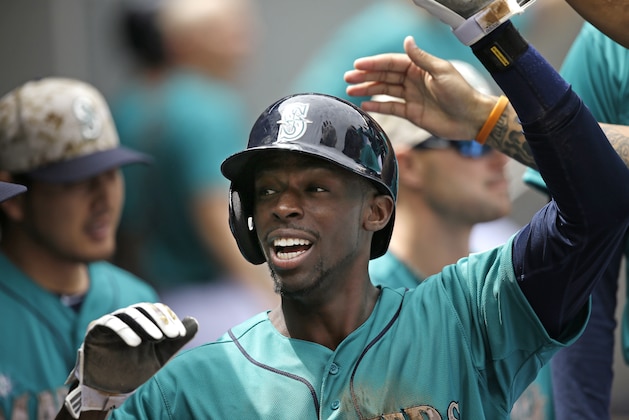 Seattle Mariners' James Jones is congratulated in the dugout after scoring against the Los Angeles Angels in the second inning of a baseball game Monday, May 26, 2014, in Seattle. (AP Photo/Elaine Thompson)
