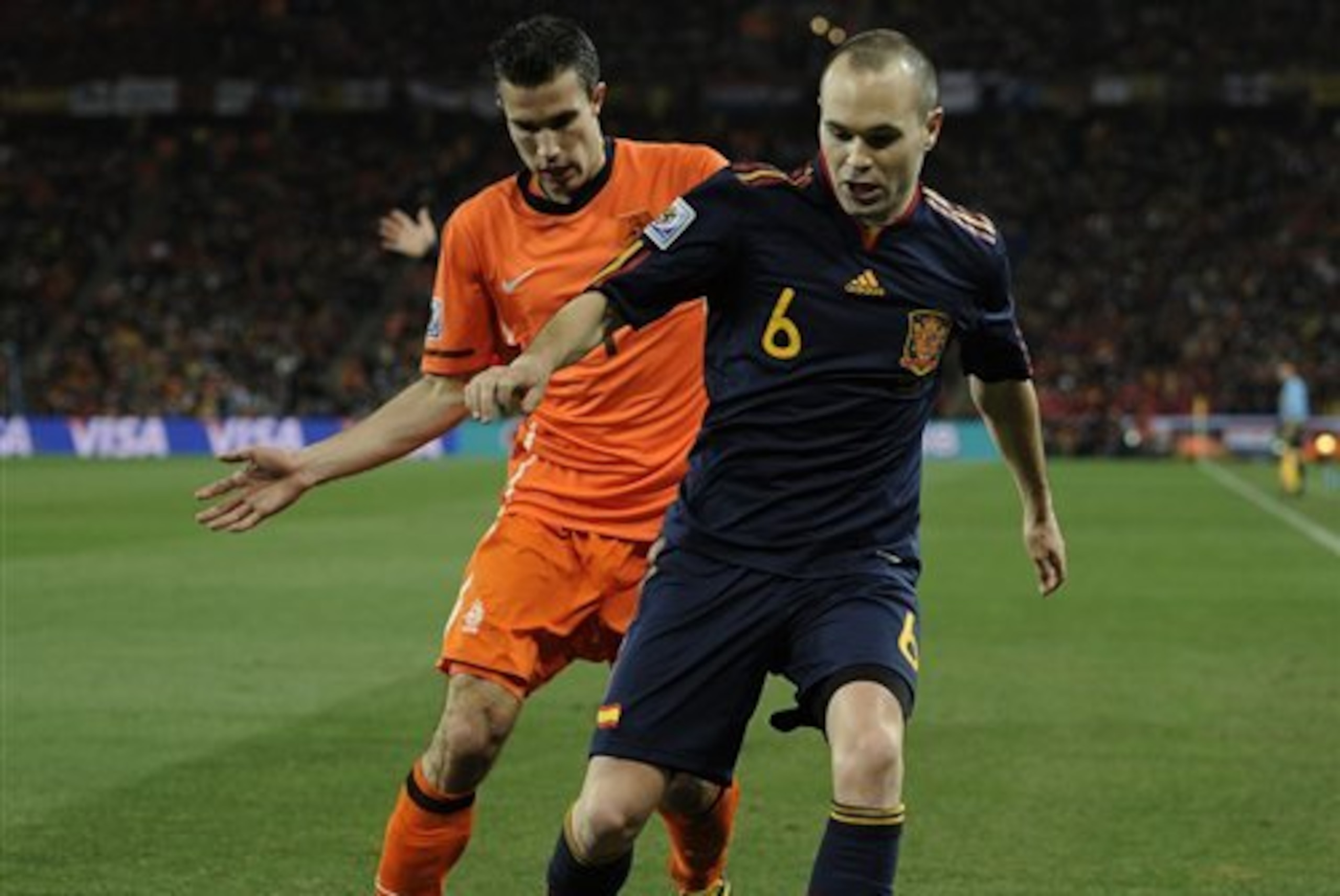 Spain's Andres Iniesta, right, and Netherlands' Robin van Persie, left during the World Cup final soccer match between the Netherlands and Spain at Soccer City in Johannesburg, South Africa, Sunday, July 11, 2010.  (AP Photo/Martin Meissner)