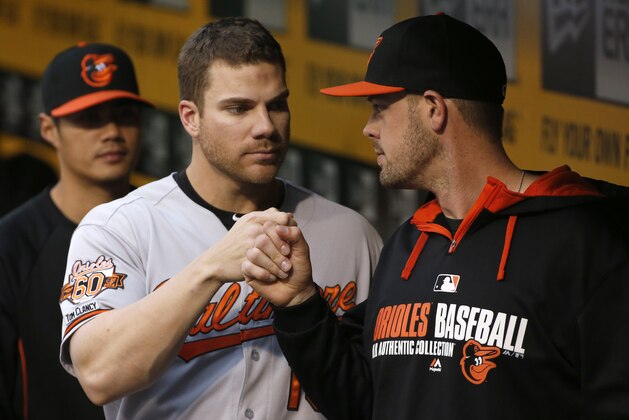 Baltimore Orioles' Chris Davis, center, bumps fists with with teammate Matt Wieters, right, in the dugout before a baseball game against the Pittsburgh Pirates in Pittsburgh Tuesday, May 20, 2014. Davis hit three home runs in the Orioles 9-2 win . (AP Photo/Gene J. Puskar)