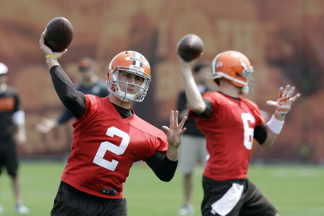 Cleveland Browns quarterback Johnny Manziel (2) passes with Brian Hoyer (6) during a practice at the NFL football team's facility in Berea, Ohio Wednesday, May 21, 2014. (AP Photo/Mark Duncan)