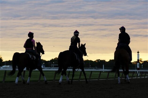 Riders excercise horses on the track at Belmont Park in Elmont, N.Y., early Wednesday, May 21, 2014. California Chrome arrived in New York on Tuesday to begin preparations for his bid to become horse racing's first Triple Crown winner in 36 years. (AP Photo/Seth Wenig)