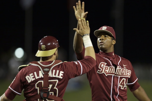 Florida State catcher Danny De La Calle (13) exchanges high-fives with pitcher Jameis Winston (44) after defeating Virginia 6-4 in the Atlantic Coast Conference college baseball tournament in Greensboro, N.C., Saturday, May 24, 2014.  (AP Photo/Bob Leverone)