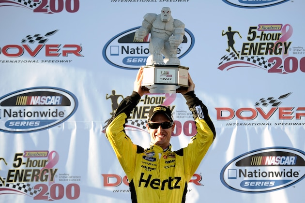 DOVER, DE - SEPTEMBER 28:  Joey Logano, driver of the #22 Hertz Ford, poses with the 'Miles the Monster' trophy after winning the NASCAR Nationwide Series 5-Hour Energy 200 Benefiting Living Beyond Breast Cancer at Dover International Speedway on September 28, 2013 in Dover, Delaware.  (Photo by Jared C. Tilton/Getty Images)