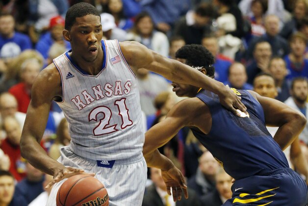 Kansas center Joel Embiid (21) pushes off West Virginia forward Devin Williams, right, during the first half of an NCAA college basketball game in Lawrence, Kan., Saturday, Feb. 8, 2014. Embiid scored 11 points in the game. Kansas defeated West Virginia 83-69. (AP Photo/Orlin Wagner)