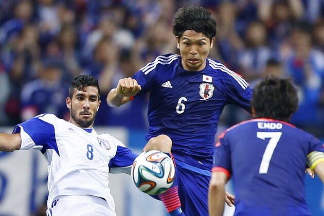 Cyprus’ Nestor Mytidis, left, fights for the ball with Japan's Masato Morishige during a friendly soccer match in Saitama, north of Tokyo, Tuesday, May 27, 2014.  Japan will play against Ivory Coast, Greece and Colombia in Group C of the World Cup 2014 in Brazil. (AP Photo/Shizuo Kambayashi)