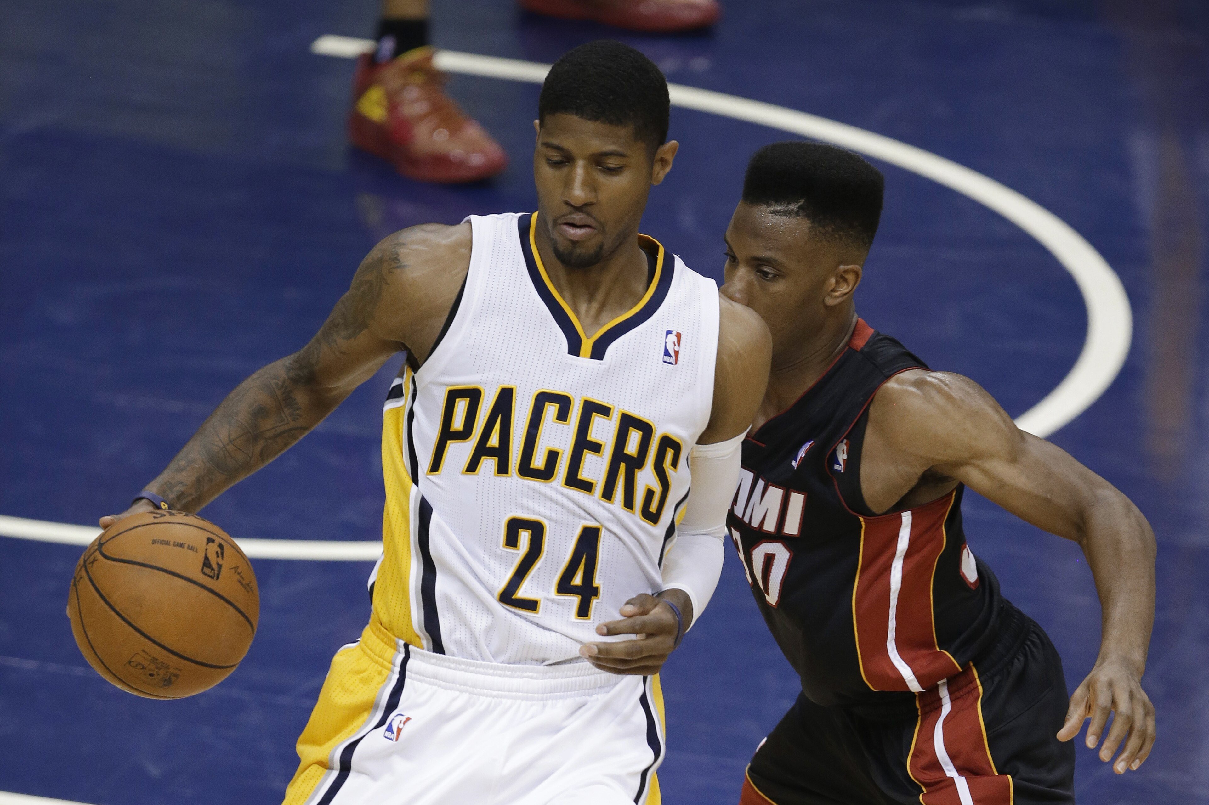 Indiana Pacers' Paul George (24) works against Miami Heat's Norris Cole during the first half of Game 5 of the Eastern Conference finals NBA basketball playoff series, Wednesday, May 28, 2014, in Indianapolis. (AP Photo/Darron Cummings)