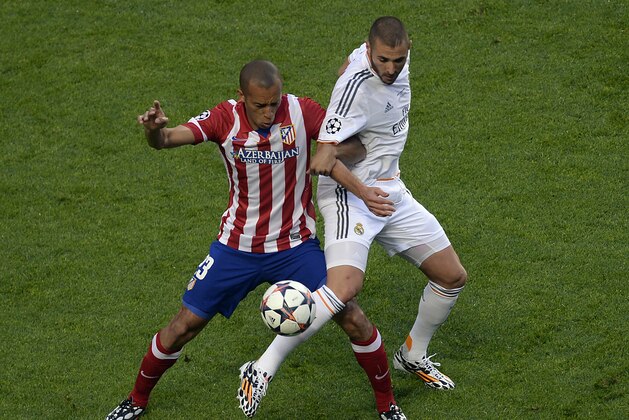 Real's Karim Benzema, right, and Atletico's Miranda during the Champions League final soccer match between Atletico Madrid and Real Madrid in Lisbon, Portugal, Saturday, May 24, 2014. (AP Photo/Paulo Duarte)