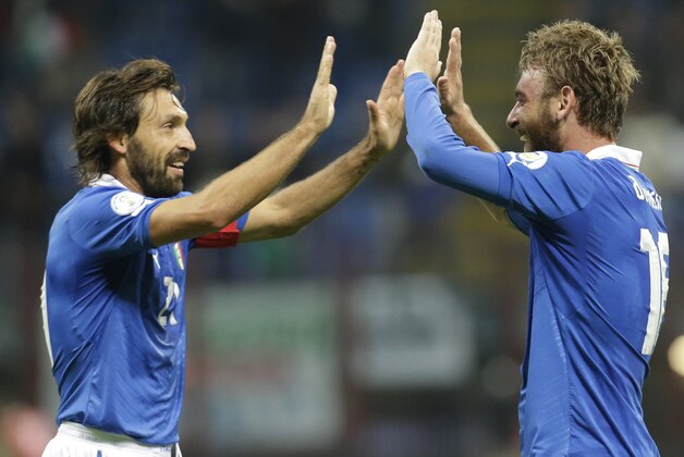 Italy midfielder Daniele De Rossi, right, celebrates with his teammate Andrea Pirlo after scoring, during a World Cup Group B qualifying soccer match between Italy and Denmark, in Milan, Italy, Tuesday, Oct.16, 2012. (AP Photo/Luca Bruno)