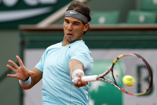 Spain's Rafael Nadal returns the ball to Austria's Dominic Thiem during their second round match of  the French Open tennis tournament at the Roland Garros stadium, in Paris, France, Thursday, May 29, 2014. (AP Photo/Darko Vojinovic)