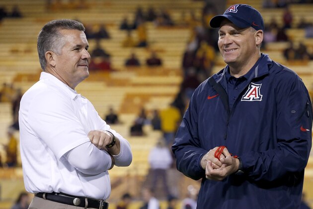 Arizona's head coach Rich Rodriguez, right, talks with Arizona State's head coach Todd Graham prior to an NCAA college football game Saturday, Nov. 30, 2013, in Tempe, Ariz.  Arizona State defeated Arizona 58-21. (AP Photo/Ross D. Franklin)