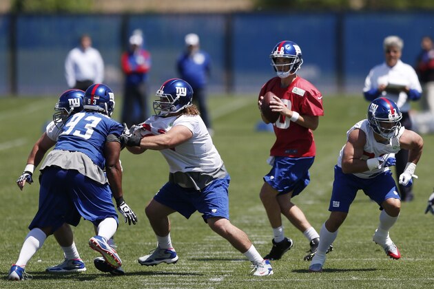 New York Giants quarterback Eli Manning, center, looks to pass during an NFL football organized team activity, Thursday, May 29, 2014, in East Rutherford, N.J. (AP Photo/Julio Cortez)