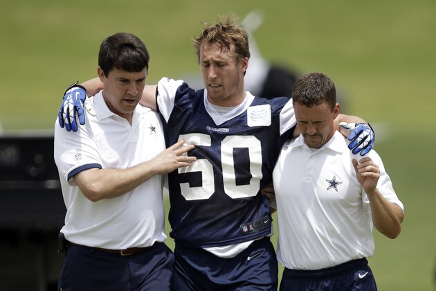 Dallas Cowboys linebacker Sean Lee is helped off the field by head athletic trainer Jim Maurer, left, and associate athletic trainer Britt Brown, right, after suffering an unknown left leg injury during an NFL football organized team activity, Tuesday, May 27, 2014, in Irving, Texas. (AP Photo/Tony Gutierrez)