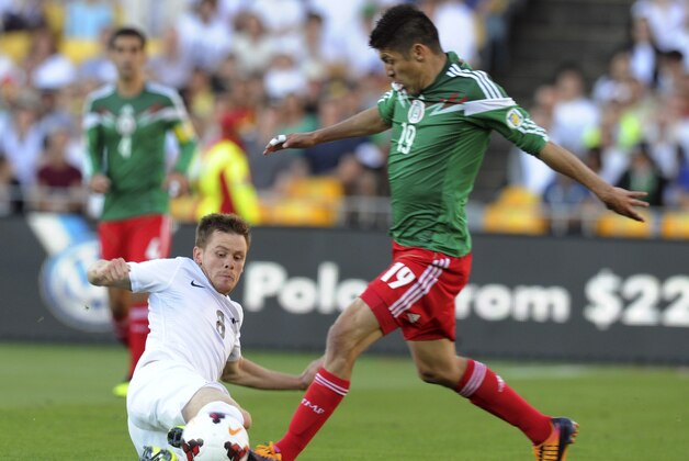 New Zealand's Michael McGlinchey, left, fights for the ball with Mexico's Oribe Peralta in the World Cup Football qualifier at Westpac Stadium in Wellington, New Zealand, Wednesday, Nov. 20, 2013. (AP Photo/SNPA, Ross Setford)  NEW ZEALAND OUT