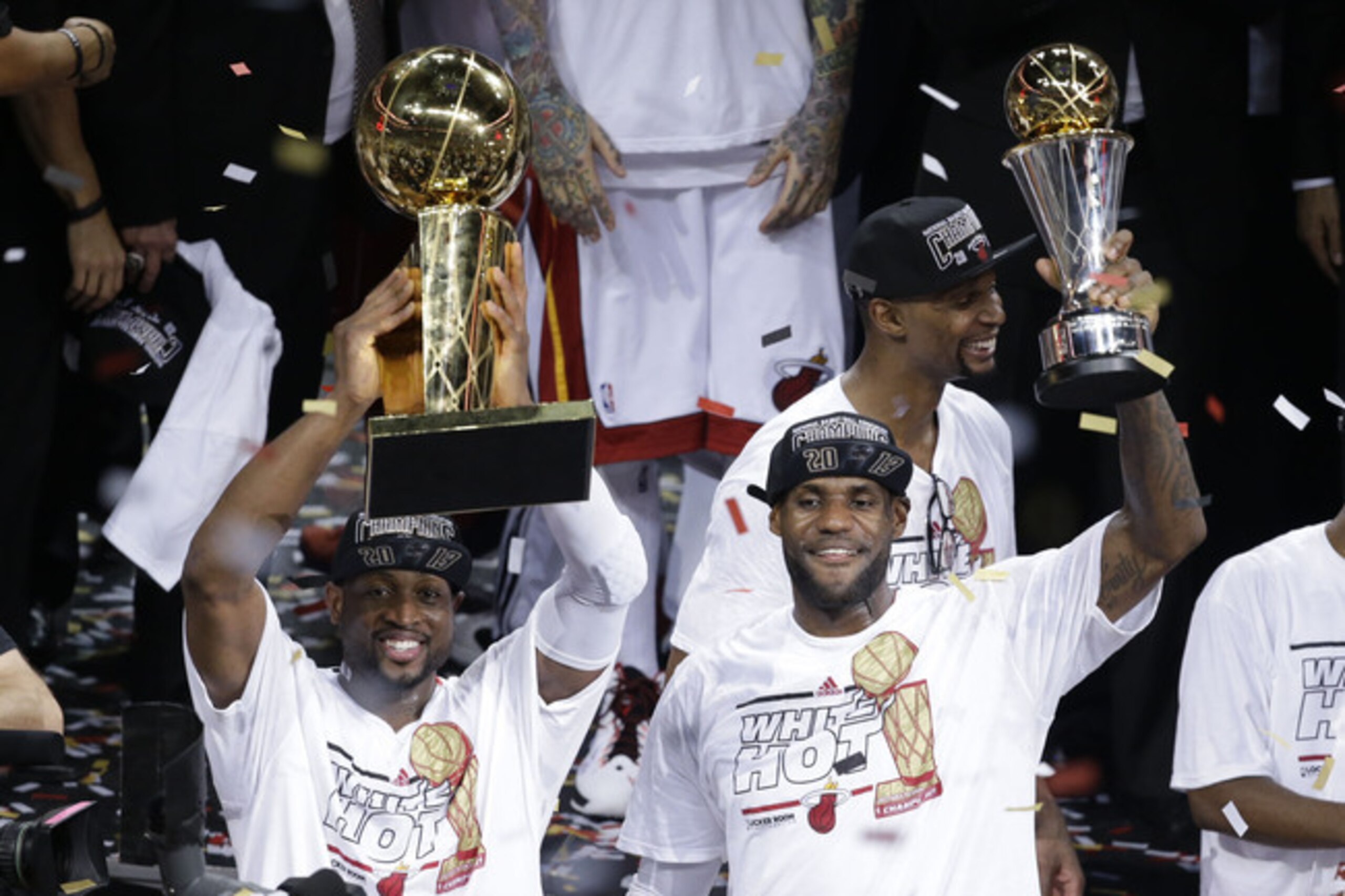 The Miami Heat's Dwyane Wade, left, holds the Larry O'Brien NBA Championship Trophy as LeBron James holds his Bill Russell NBA Finals Most Valuable Player Award after Game 7 of the NBA basketball championship game against the San Antonio Spurs, Friday, June 21, 2013, in Miami. The Miami Heat defeated the San Antonio Spurs 95-88 to win their second straight NBA championship. (AP Photo/Wilfredo Lee)