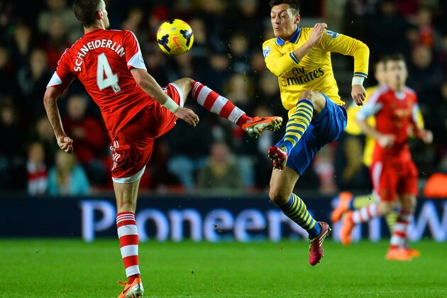 SOUTHAMPTON, ENGLAND - JANUARY 28: Morgan Schneiderlin of Southampton and Mesut Oezil of Arsenal compete for the ball during the Barclays Premier League match between Southampton and Arsenal at St Mary's Stadium on January 28, 2014 in Southampton, England.  (Photo by Mike Hewitt/Getty Images)