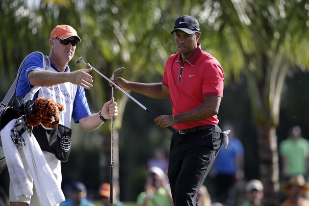 Tiger Woods, right, exchanges clubs with his caddie Joe LaCava, left, during the final round of the Cadillac Championship golf tournament Sunday, March 9, 2014, in Doral, Fla. (AP Photo/Lynne Sladky)