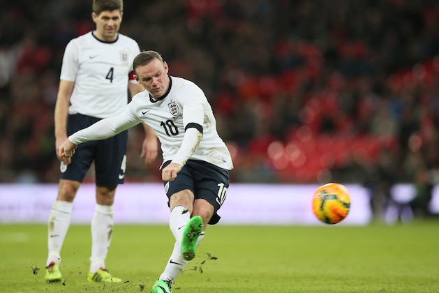 England's Wayne Rooney takes a direct free kick watched by teammate Steven Gerrard during the international friendly soccer match between England and Denmark at Wembley stadium in London Wednesday, March  5,  2014. (AP Photo/Alastair Grant)