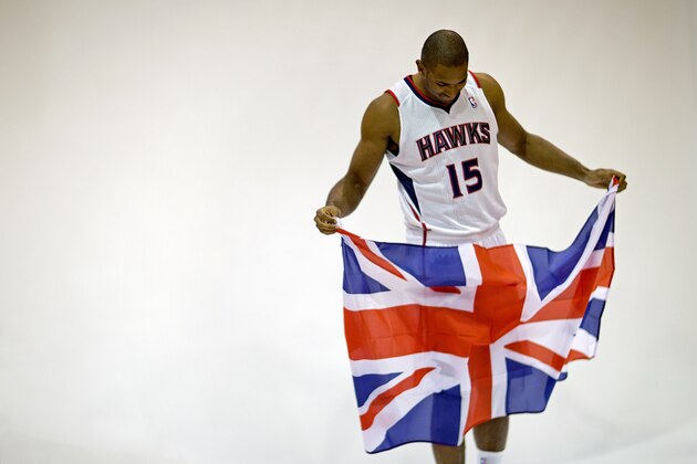 Atlanta Hawks' Al Horford holds a British flag given to him by a photographer before posing for a photo during their NBA basketball media day, Monday, Sept. 30, 2013, in Atlanta. The flag references the team's trip to London in January to face the Brooklyn Nets. (AP Photo/David Goldman)