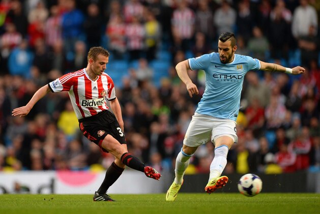 MANCHESTER, ENGLAND - APRIL 16: Lee Cattermole of Sunderland and Alvaro Negredo of Manchester City compete for the ball during the Barclays Premier League match between Manchester City and Sunderland at Etihad Stadium on April 16, 2014 in Manchester, England.  (Photo by Michael Regan/Getty Images)