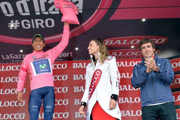 Colombia's Nairo Quintana is applauded by Formula One driver Fernando Alonso, right, as he celebrates on the podium after completing the 18th stage of the Giro d'Italia cycling race from Belluno to Rifugio Panarotta, Italy, Thursday, May 29, 2014. Julian Arredondo of Colombia claimed the biggest win of his career with a solo victory on the 18th stage of the Giro d'Italia on Thursday, while Nairo Quintana retained the overall leader's pink jersey as the race returned to the mountains. (AP Photo/Gian Mattia D'Alberto)