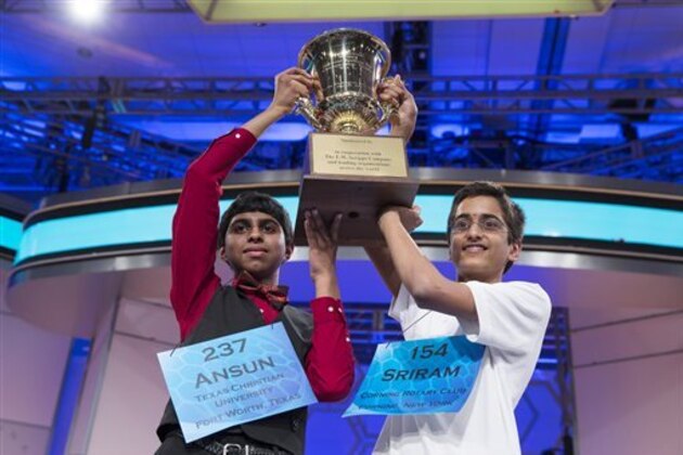 Ansun Sujoe, 13, of Fort Worth, Texas, left, and Sriram Hathwar, 14, of Painted Post, N.Y., raise the championship trophy after being named co-champions of the National Spelling Bee, on Thursday, May 29, 2014, in Oxon Hill, Md. (AP Photo/Evan Vucci)