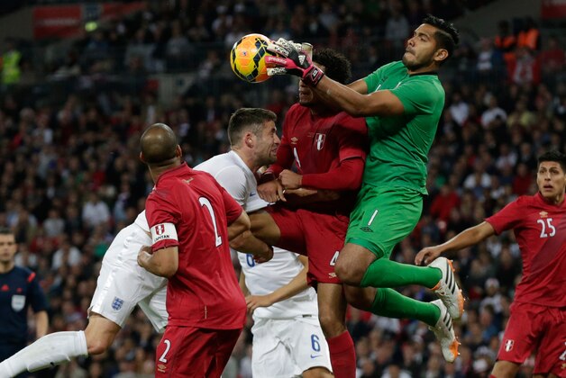England's Gary Cahill, second left, competes for the ball with Peru's Alexander Callens, center, and goalkeeper Raul Fernandez, second right, during the international friendly soccer match between England and Peru at Wembley Stadium in London, Friday, May 30, 2014.  (AP Photo/Matt Dunham)
