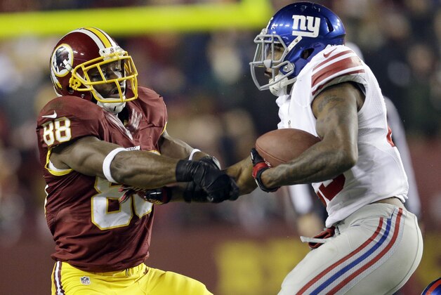 El defensivo de los Giants Will Hill (derecha) le arranca el balón al receiver de los Redskins Pierre Garcon (88) durante la segunda parte del juego del domingo 1 de diciembre de 2013. (Foto de AP/Patrick Semansky)