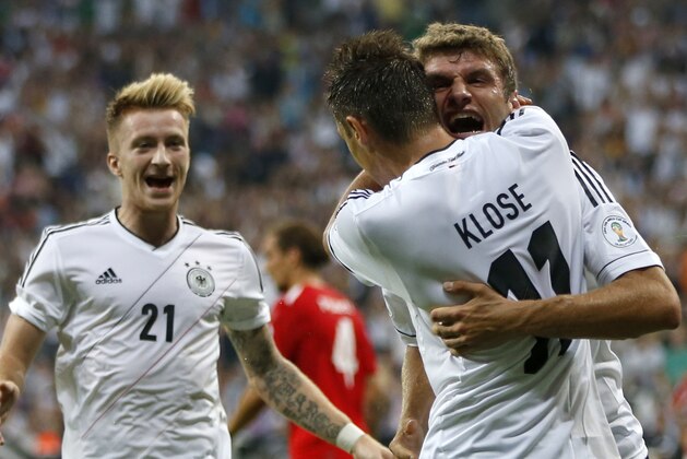 Germany's Miroslav Klose hugs team mate Thomas Mueller after scoring his side's opening goal  during their FIFA World Cup 2014 qualification group C soccer match between Germany and Austria in Munich, southern Germany, Friday, Sept. 6, 2013. Left team mate Marco Reus. (AP Photo/Matthias Schrader)