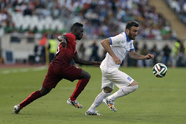 Greece's Vasilis Torosidis, right, vies for the ball with Portugal's Varela during a friendly soccer match between Portugal and Greece at the National stadium, in Oeiras, near Lisbon, Saturday, May 31, 2014. The game is a warm-up match for both teams ahead the World Cup in Brazil. (AP Photo/Francisco Seco)