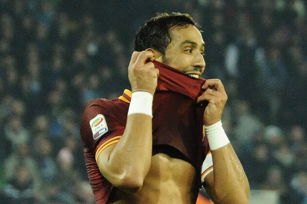 AS Roma's Mehdi Benatia bites his jersey after he scored a disallowed goal in offside during a Serie A soccer match between Napoli and Roma, at the San Paolo stadium in Naples, Italy, Sunday, March 9, 2014. (AP Photo/Salvatore Laporta)