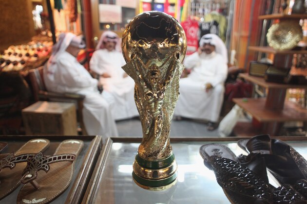 DOHA, QATAR - OCTOBER 24:  Arab men sit at a shoemaker's stall with a replica of the FIFA World Cup trophy in the Souq Waqif traditional market on October 24, 2011 in Doha, Qatar. Qatar will host the 2022 FIFA World Cup football competition and is slated to tackle a variety of infrastructure projects, including the construction of new stadiums.  (Photo by Sean Gallup/Getty Images)