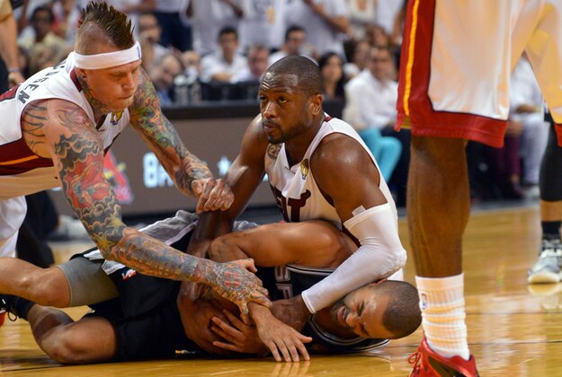 Jun 20, 2013; Miami, FL, USA; San Antonio Spurs point guard Tony Parker (9) and Miami Heat shooting guard Dwyane Wade (3) and power forward Chris Andersen (11) hold onto a jump ball during the fourth quarter of game seven in the 2013 NBA Finals at American Airlines Arena. Mandatory Credit: Steve Mitchell-USA TODAY Sports