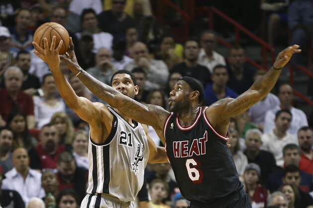 Miami Heat's LeBron James (6) fouls San Antonio Spurs' Tim Duncan (21) as he tries to steal the ball during the second half of an NBA basketball game in Miami, Sunday, Jan. 26, 2014. The Heat won 113-101. (AP Photo/J Pat Carter)