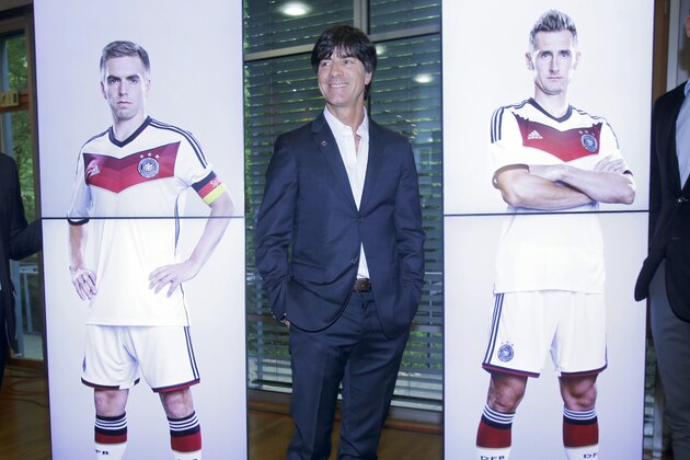 Coach of German national soccer team Joachim Loew stands next to pictures of players Philipp Lahm, left, and Miroslav Klose after a press conference where he presented his preliminary team for the upcoming World Cup in Brazil in Frankfurt, Germany, Thursday, May 8, 2014. (AP Photo/Michael Probst)