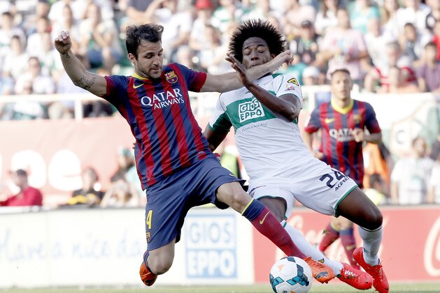Barcelona's Cesc Fabregas, left,  duels the ball with Carlos Alberto Sanchez Moreno during a Spanish La Liga soccer match at the Martinez Valero stadium in Elche, Spain, on Sunday, May 11, 2014. (AP Photo/Alberto Saiz)