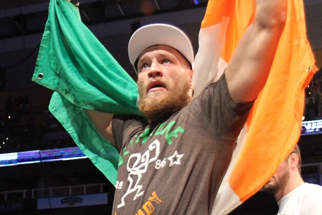 Conor McGregor, of Ireland, leaves the ring draped in an Irish flag after beathing Max Holloway in their UFC on Fox Sports 1 mixed martial arts bout in Boston, Saturday, August 17,2013. McGregor won via unanimous decision. (AP Photo/Gregory Payan)