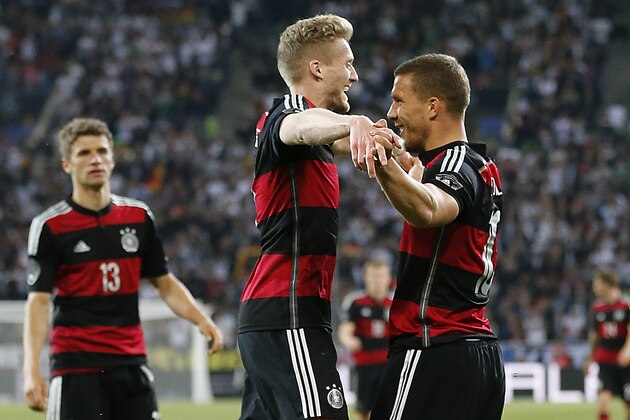 Germany's Thomas Mueller\, from left, Germany's Andre Schuerrle\ and Germany's Lukas Podoslki celebrate scoring during a friendly WCup preparation soccer match between Germany and Cameroon in Moenchengladbach, Germany, Monday, June 2, 2014. (AP Photo/Frank Augstein)