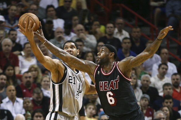 Miami Heat's LeBron James (6) fouls San Antonio Spurs' Tim Duncan (21) as he tries to steal the ball during the second half of an NBA basketball game in Miami, Sunday, Jan. 26, 2014. The Heat won 113-101. (AP Photo/J Pat Carter)